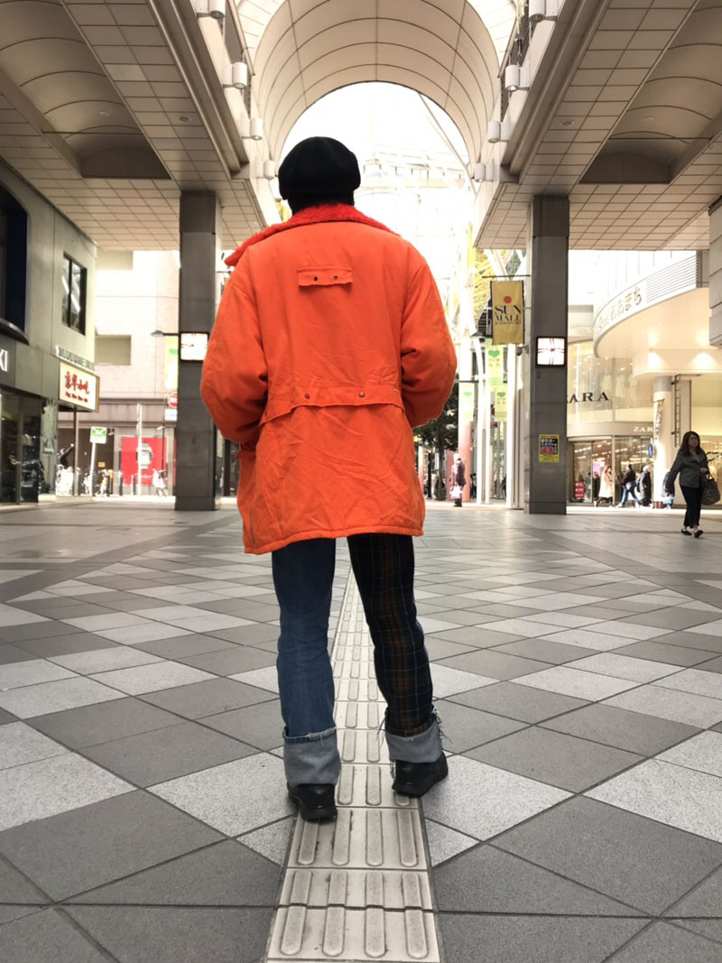 オレンジのジャケットを着る男性